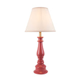 Endon Carlworth Ivy table lamp with a turned pink clay resin spindle base, brass lamp holder and tapered vintage white fabric shade on a plain background.