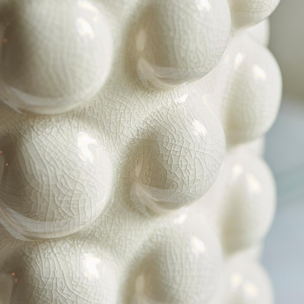 Close-up of the Amberley Ikat Table Lamp's sculptured white ceramic bobble base, showing a glossy crackle-glaze textured surface.