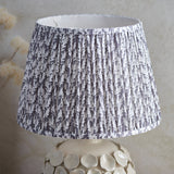 Ashbury Leaf Table Lamp in grey with pleated leaf-print fabric shade on a sculptured ceramic base featuring raised pebble detail.