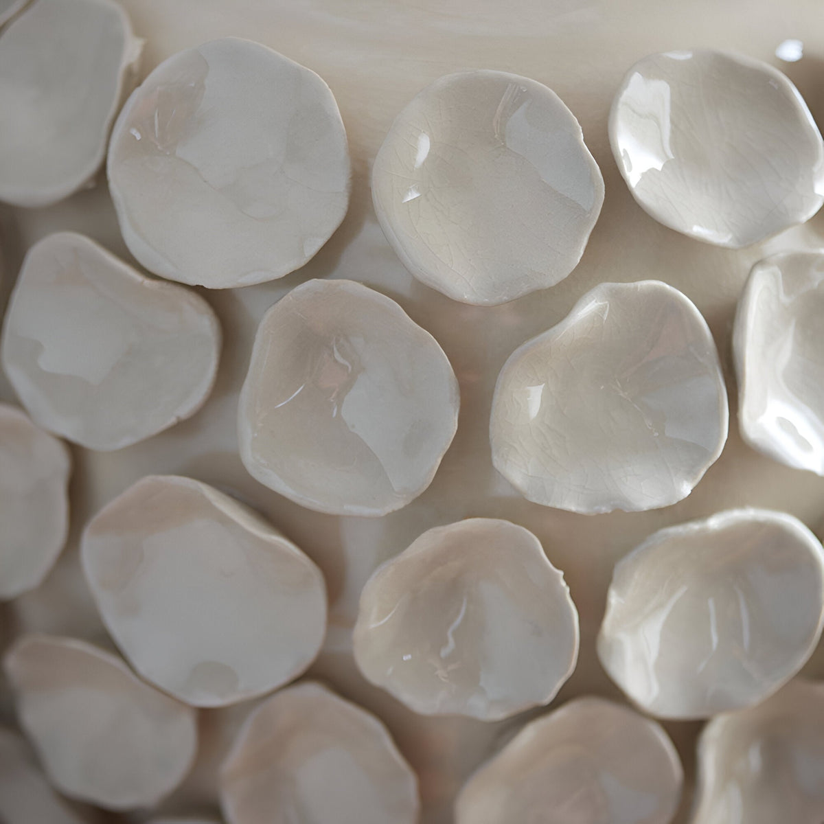 Close-up of the Ashbury table lamp base showing sculptured ceramic leaf-like discs with an ivory crackle glaze finish.