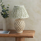 Endon Caldford ceramic table lamp with ivory crackle-glazed artichoke base and pleated green leaf-print shade, styled on a wooden console with eucalyptus.