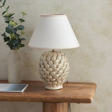 Caldford Ivy 30cm Table Lamp in white, showing a ceramic leaf-textured base with brass stem and white fabric shade, styled on a wooden console table.
