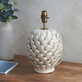 Endon Caldford table lamp base in ivory crackle-glazed ceramic with leaf-shaped details and aged brass B22 holder, on a wood surface beside a vase.