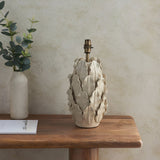 Endon Caldford ceramic table lamp base in ivory crackle glaze with leaf details and brass B22 holder, on a wooden console beside a vase of eucalyptus.