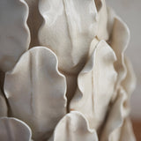 Close-up of the Endon Caldford table lamp base showing ivory crackle-glazed ceramic with handmade leaf-shaped details.