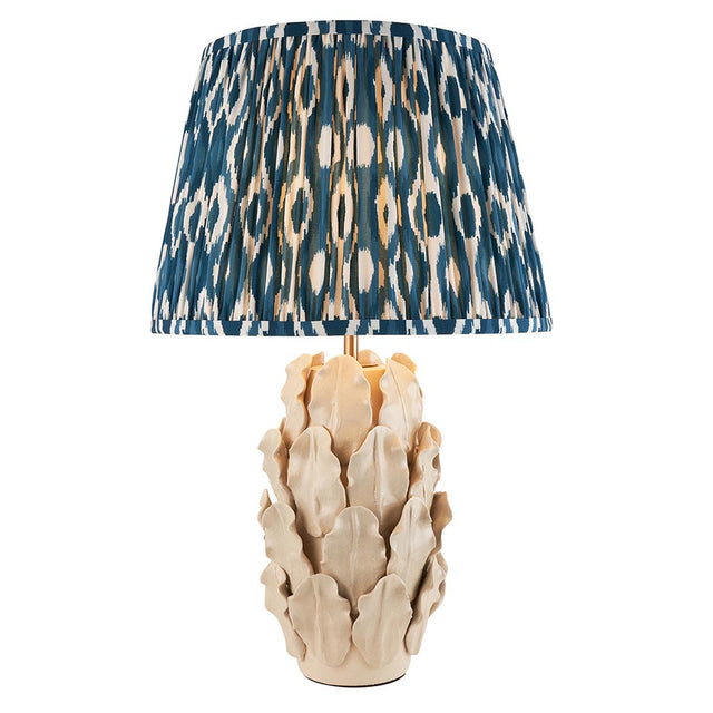 Endon Caldford Ikat 35cm table lamp with sculpted ivory ceramic leaf base and pleated blue and cream Ikat fabric shade on a white background.