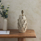 Endon Caldford ceramic table lamp base with sculpted leaf detailing in ivory crackle glaze and brushed brass B22 holder, on a wooden console beside a vase.