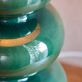 Close-up of the Carlstead Ikat Table Lamp base in dark green ceramic, showing a glossy, crackled reactive glaze with tiered, rounded gourd-inspired form.