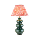 Carlstead Ikat Table Lamp with a tiered, glossy dark green ceramic base and a pink patterned pleated fabric shade, shown on a plain white background.