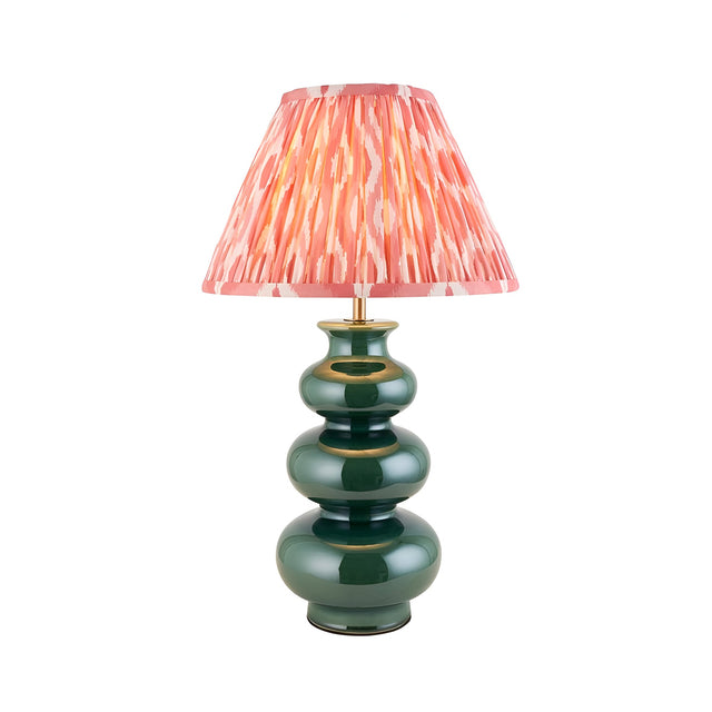 Carlstead Ikat Table Lamp with a tiered, glossy dark green ceramic base and a pink patterned pleated fabric shade, shown on a plain white background.