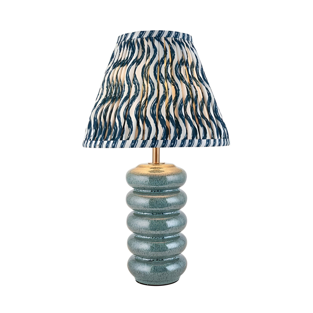 Cliffstead Table Lamp featuring a ribbed ceramic base in blue reactive glaze, brass fittings, and a pleated blue-and-white patterned fabric shade.