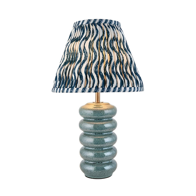 Cliffstead Table Lamp featuring a ribbed ceramic base in blue reactive glaze, brass fittings, and a pleated blue-and-white patterned fabric shade.