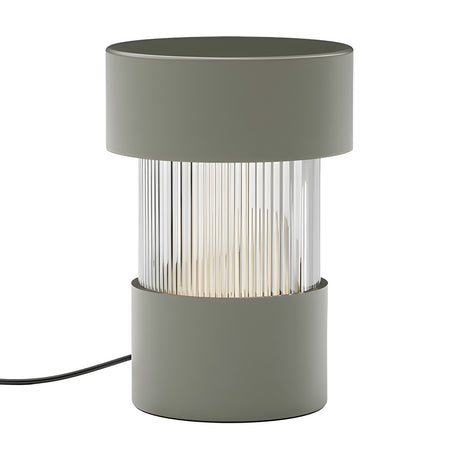 Balise Cylinder Ribbed Glass Lantern Table Lamp in green, with solid iron top and base framing a fluted glass midsection, shown on a plain white background.