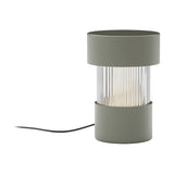 Balise Cylinder Ribbed Glass Lantern Table Lamp in green, with iron top and base framing a fluted glass midsection, shown on a plain white background.