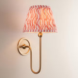Endon Cliffleigh Ripple wall light in brushed aged brass with slim curved arm and tapered hand-pleated coral pink faux linen shade.
