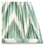 Close-up of the Endon Cliffleigh wall light's tapered Zigzag shade, hand-pleated in green and white faux silk with taped edge detailing.