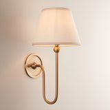 Cliffleigh Wall Light in Ivy, a single-light fixture with a slim antique brass arm, round backplate, and tapered vintage white fabric shade.