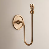 Cliffleigh Wall Light in Ivy, an antique brass single-arm wall light with round backplate, curved rise, and B22 holder, shown shadeless.