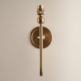 Cliffleigh Wall Light in Ivy shown without shade, featuring a round backplate, slim upright brass arm and B22 lamp holder on a plain light background.