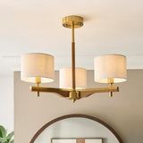 Bramwell 3 Light semi-flush ceiling light with aged brass frame, oak arms and linen drum shades, shown fitted in a room with an arched mirror below.