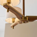 Close-up of the Bramwell 3 Light Oak & Linen Semi-Flush Ceiling Light, showing aged brass fittings and oak arms with linen shades against a plain background.