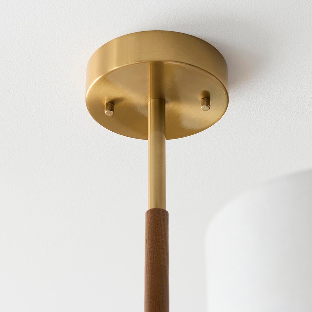 Close-up of the Bramwell semi-flush ceiling light's aged brass ceiling plate with oak-detailed rod, shown against a plain white background.