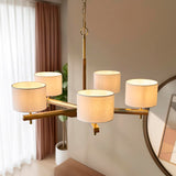 Bramwell 5 Light Pendant with brass and wood frame, five natural linen cylinder shades and chain suspension, shown above a table in a living space.