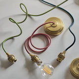 Brackmont Ripple Pendant in blue, brushed brass ceiling rose and lamp holders with green, pink and blue fabric flex cables, B22 bulb, on a white background.
