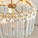 Close-up of Endon Danebury 3 Light Pendant showing tiered clear glass rods around a brushed brass frame with central rod and disc detail.