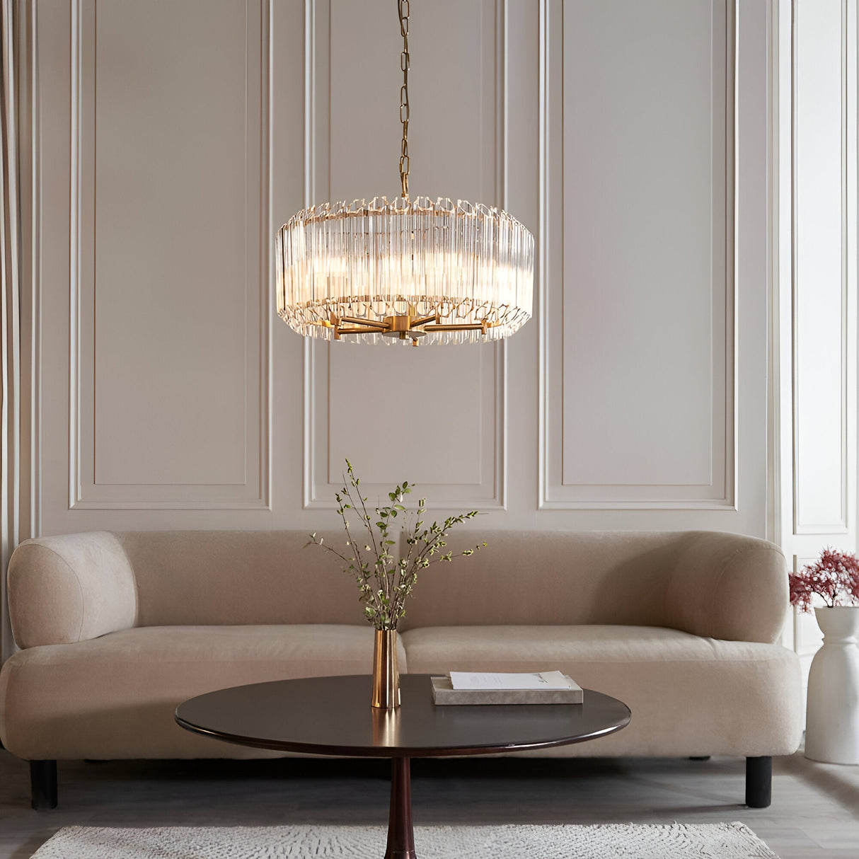 Endon Danebury 5 light pendant in aged brass with clear cut crystal rods on a chain suspension, above a coffee table and cream sofa in a panelled lounge.
