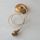 Endon Brackmont flex set with brushed aged brass ceiling rose, B22 lampholder and coiled natural braided fabric cable on a light background.