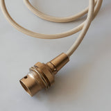 Endon Brackmont pendant flex set with brushed aged brass B22 lampholder and coiled natural braided fabric cable on a light background.