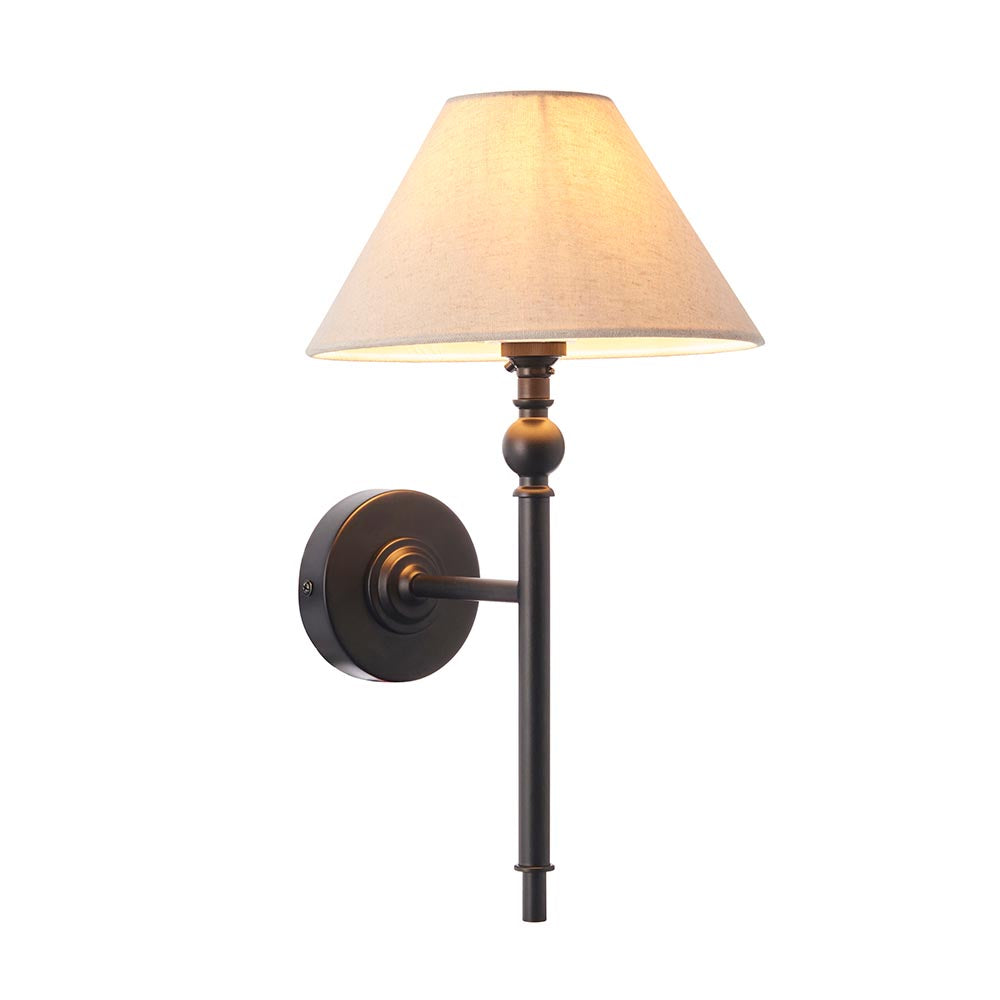 Endon Caldmere wall light with a tapered natural linen shade on a matt black metal stem and round backplate, shown against a plain white background.