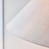 Close-up of the Endon Caldmere floor lamp's tapered natural linen shade, showing woven texture against a white wall.