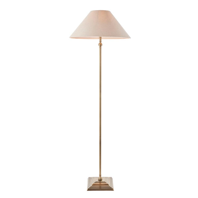 Endon Caldmere floor lamp in antique brass with a tapered natural linen shade on a stepped square base, shown against a plain white background.