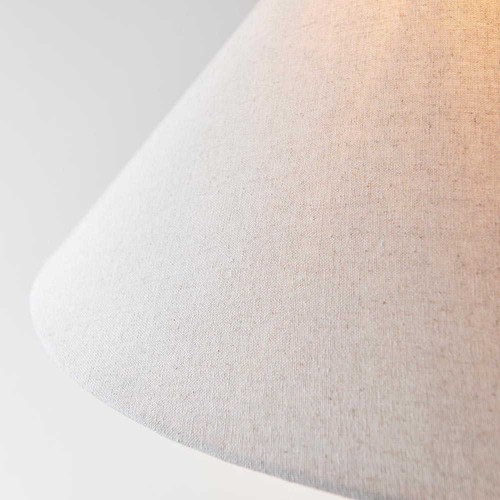 Close-up of the Endon Caldmere floor lamp's tapered natural linen fabric shade, showing the woven texture against a soft light background.