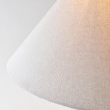 Close-up of the Endon Caldmere floor lamp's tapered natural linen fabric shade, showing the woven texture against a soft light background.