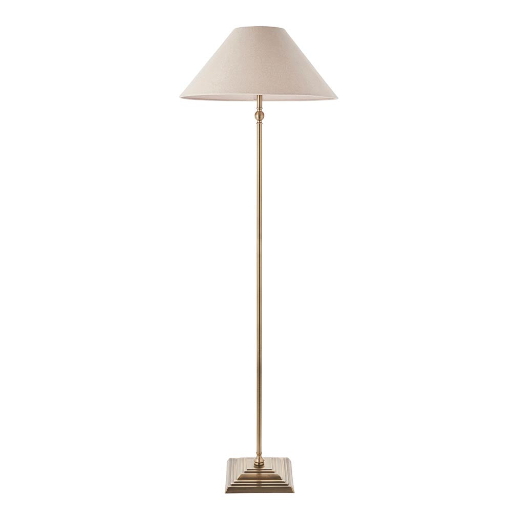 Endon Caldmere floor lamp in antique brass with a tapered natural linen shade on a stepped square base, shown against a plain white background.