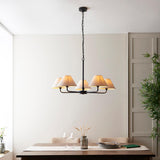 Endon Caldmere 5 Light Large Pendant in black with five tapered natural linen shades on a chain suspension, above a wooden dining table.