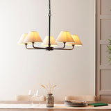 Endon Caldmere 5 Light Large Pendant in black with five tapered natural linen shades on a wide frame, hung above a dining table setting.