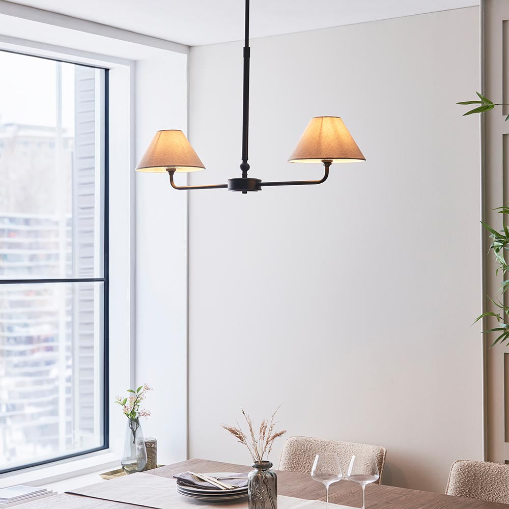 Endon Caldmere 2 light pendant with tapered natural linen shades on a slim black bar and telescopic stem, hung in a bright dining room by a window.