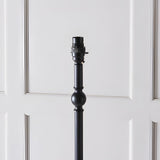 Caldmere Ikat Floor Lamp base in matt black metal with turned column and ball detail, B22 bulb holder shown against a light panelled background.