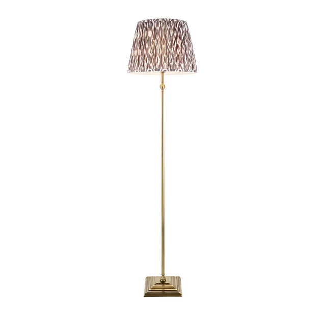 Caldmere Ikat Floor Lamp in Grey with antique brass stem, square base, and pleated grey Ikat-pattern fabric shade on a white background.