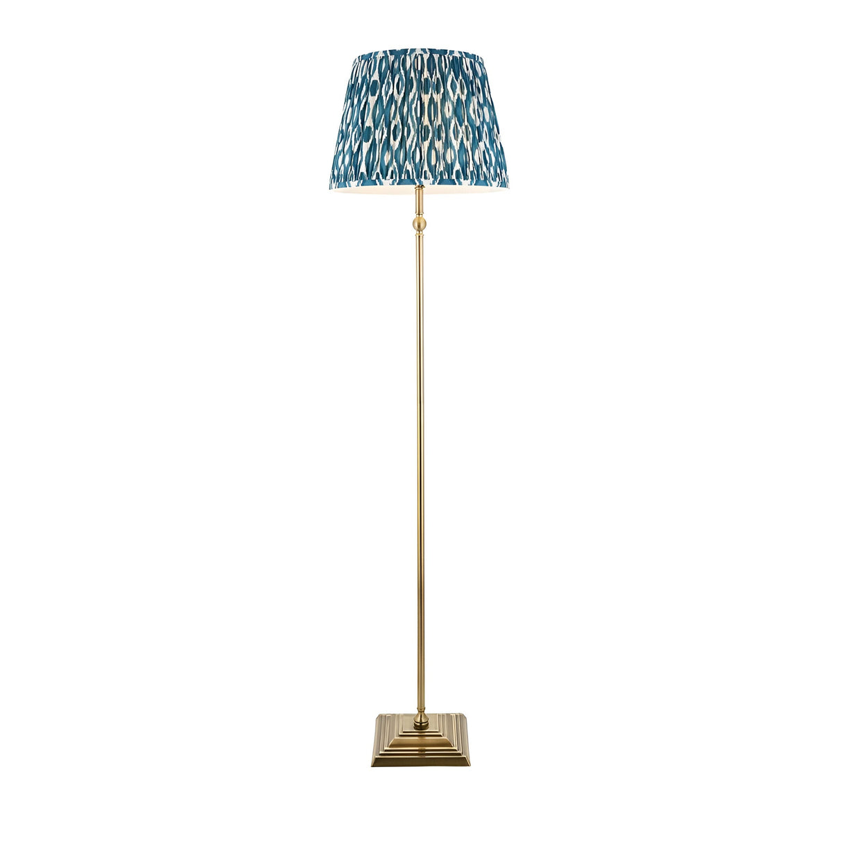 Endon Caldmere floor lamp with antique brass stem and stepped square base, topped with a pleated marlin blue Ikat fabric shade on a white background.