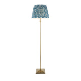 Endon Caldmere floor lamp with antique brass stem and stepped square base, topped with a pleated marlin blue Ikat fabric shade on a white background.