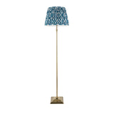 Endon Caldmere floor lamp with antique brass stepped square base, slim stem and pleated marlin blue Ikat fabric shade, on a plain white background.
