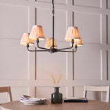 Caldmere 5 Light Ikat Pendant in Natural, matt black metal frame with five pleated fabric shades, shown above a dining table in a panelled room.