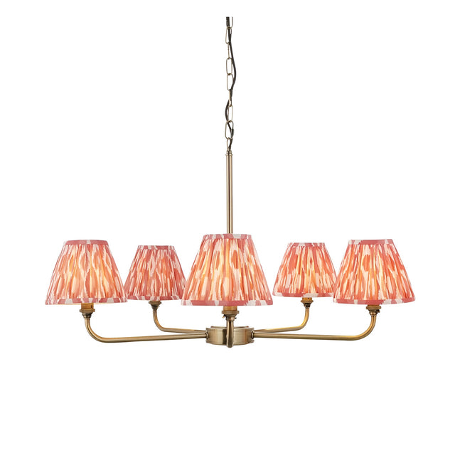 Endon Caldmere 5 light pendant with antique brass arms and tapered pleated coral ikat fabric shades, suspended from a chain on a plain background.