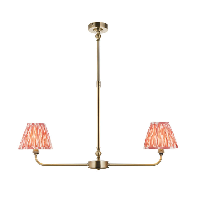 Endon Caldmere 2 light linear pendant in antique brass with two tapered coral pink ikat pleated fabric shades on a telescopic stem.