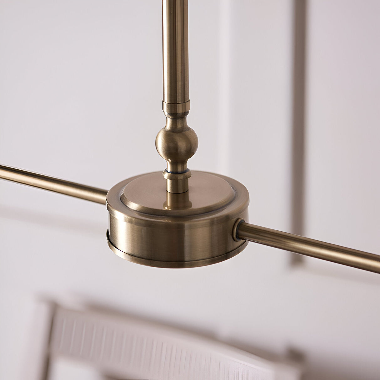 Close-up of the Caldmere 2-Light Ikat Pendant showing its antique brass frame, rounded canopy, telescopic stem, and linear crossbar on a white background.